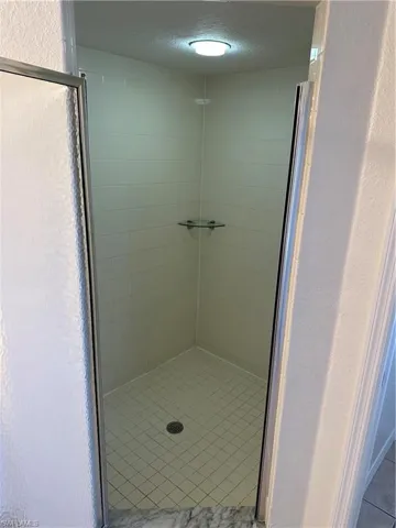 Bathroom featuring a textured ceiling and walk in shower