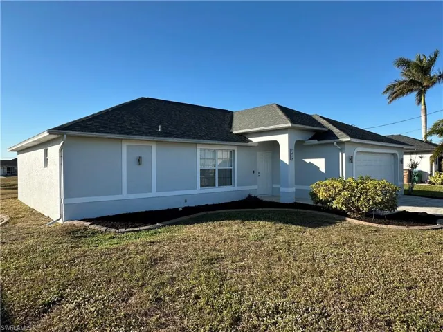 Single story home featuring a garage and a front yard