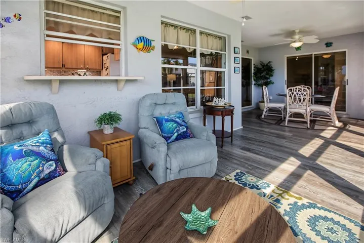 Enclosed patio featuring wood-finish flooring, sliding glass doors, and a ceiling fan