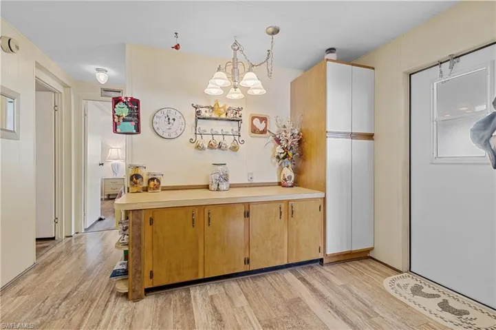 Kitchen with hanging light fixtures, light countertops, a chandelier
