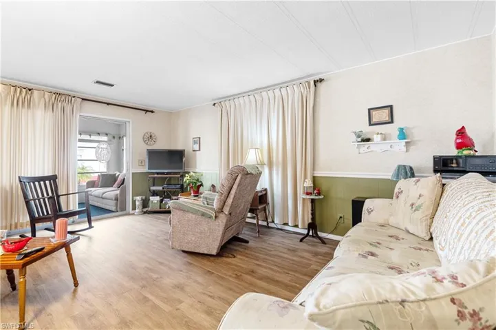 Living area featuring a wainscoted wall and light wood-style floors