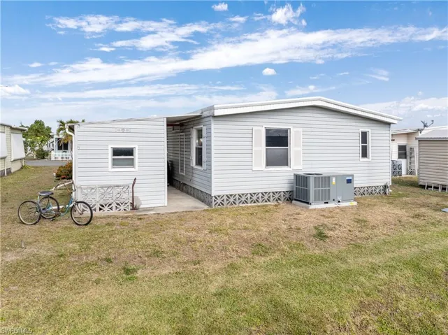 Rear view of property featuring a lawn and a patio