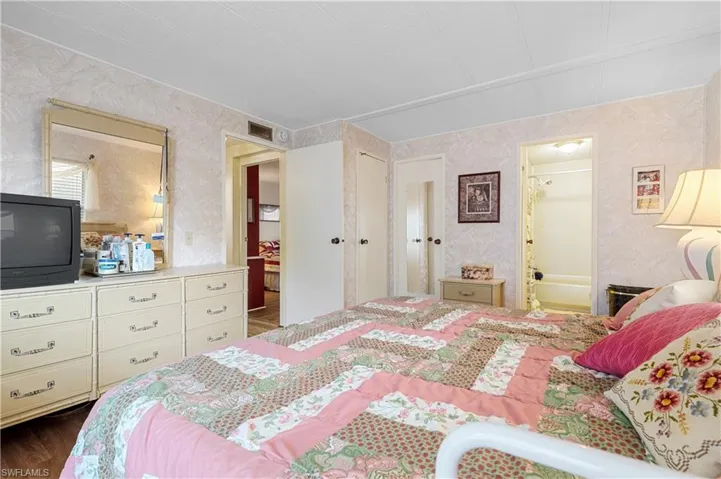 Bedroom with wallpapered walls, a closet and ensuite bath