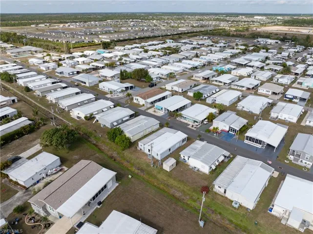 Aerial view of property and surrounding area featuring nearby suburban area