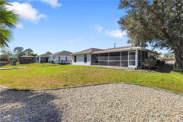 Rear view of property with lanai and a fenced backyard