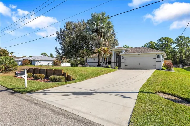 View of front of home with driveway, an attached garage, and stucco siding