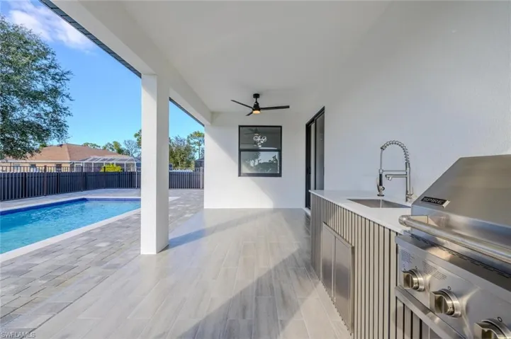View of swimming pool with a patio and an outdoor kitchen