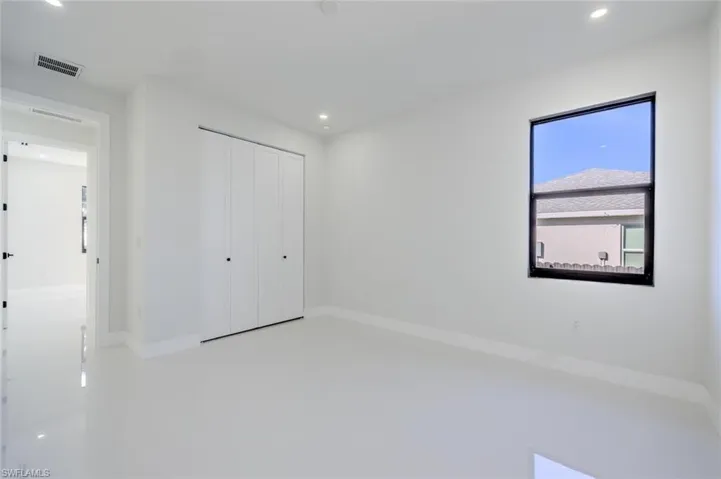 Unfurnished bedroom with recessed lighting, a closet, and finished concrete flooring