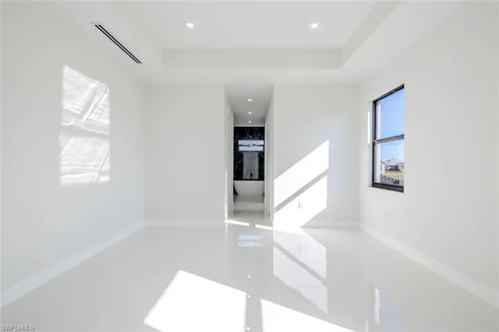 Empty room with a tray ceiling and recessed lighting
