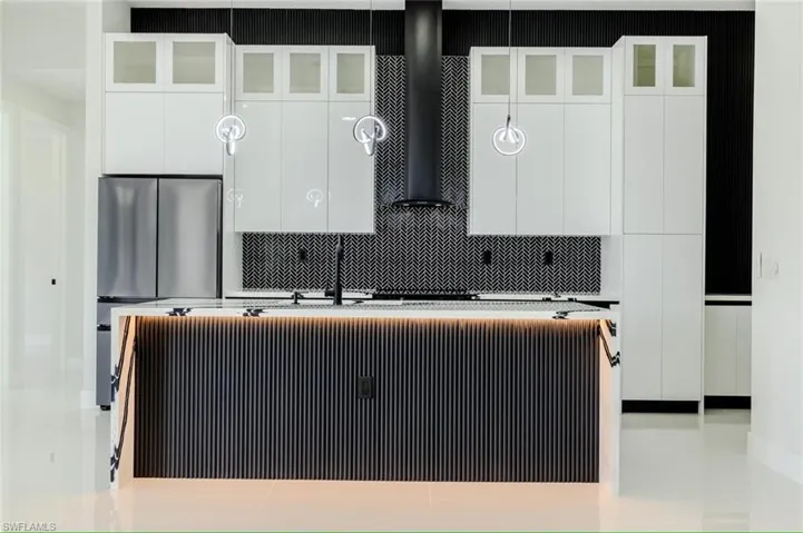 Kitchen featuring modern cabinets, white cabinets, and an island with sink