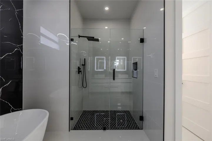 Bathroom with a shower stall and a freestanding bath