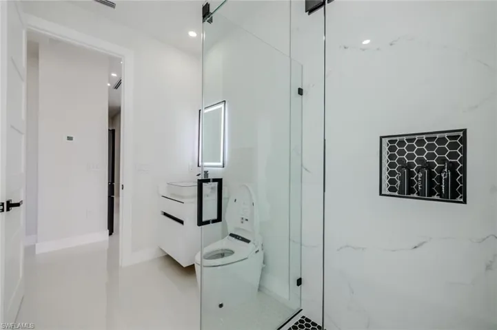 Full bathroom featuring vanity, recessed lighting, and a marble finish shower