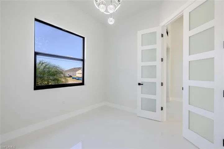 Unfurnished room featuring a chandelier