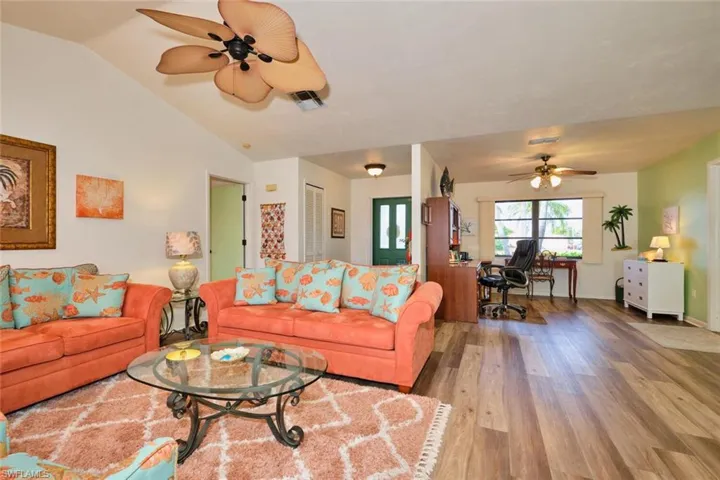 Living room with den and foyer in the background.  Door to the left is the main bedroom/bath.