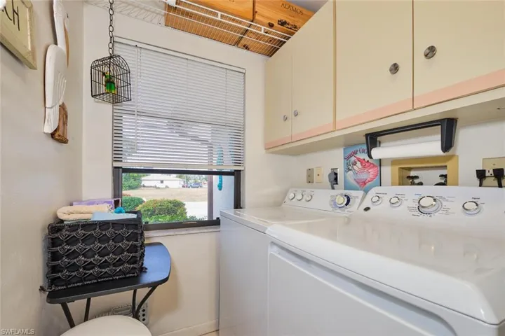 Laundry area with cabinets and separate washer and dryer & spare refrigerator.