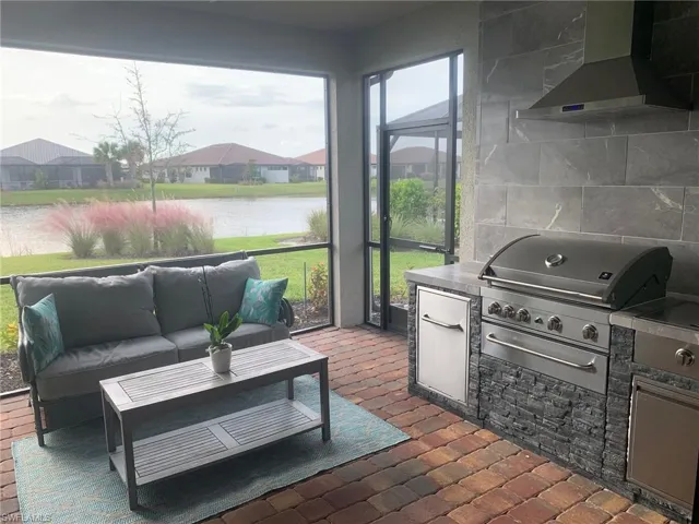 Sunroom featuring a water view and a residential view