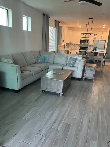 Living room featuring wood tiled floors, a ceiling fan, and recessed lighting