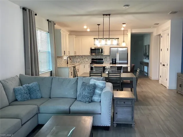 Living area with dark wood-type flooring and recessed lighting