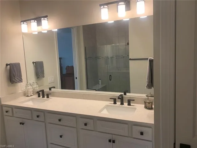 Full bath with double vanity and a stall shower
