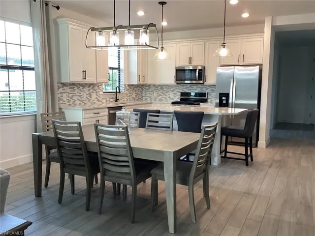 Dining room with light wood-type flooring and recessed lighting