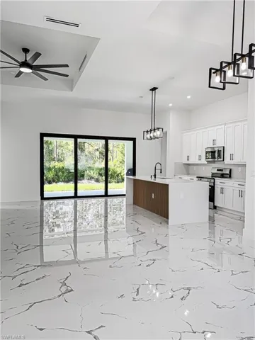 Open concept living space featuring large format marble-look tile flooring