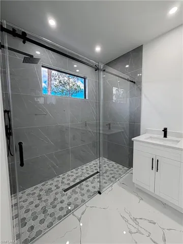 Contemporary bathroom featuring a spacious glass-enclosed shower with matte black hardware