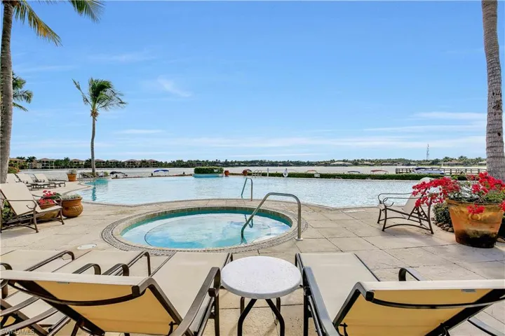 Community pool with a hot tub, a patio area, and a water view
