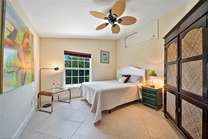 Bedroom with light tile patterned floors, a ceiling fan, and lofted ceiling