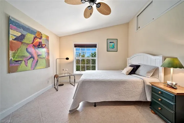 Bedroom featuring lofted ceiling, ceiling fan, and light tile patterned floors