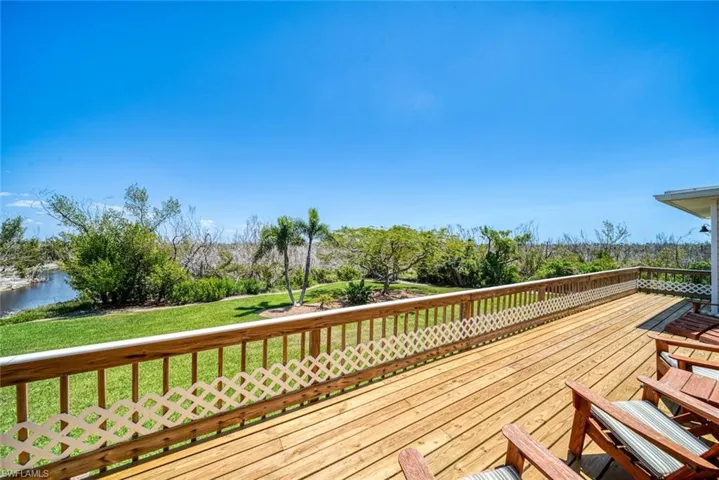 Deck with a yard and a water view