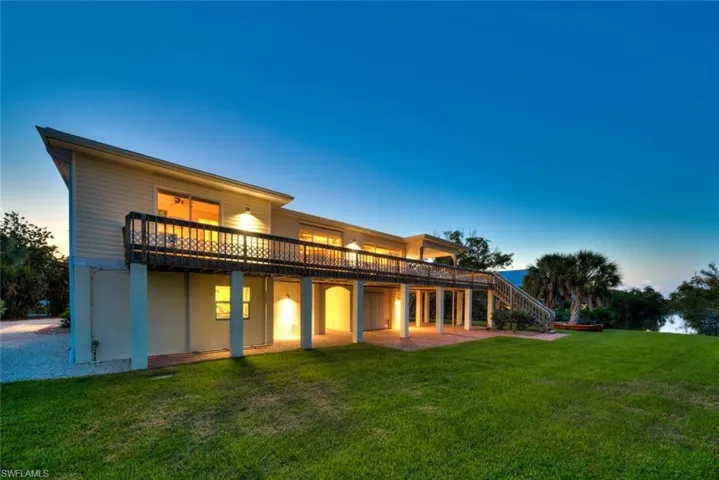 Back of property featuring a patio area, a lawn, and stairway