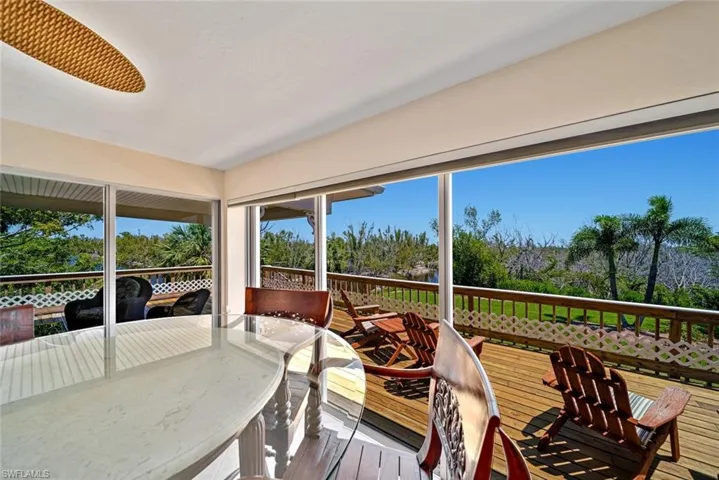 Sunroom with hardwood / wood-style floors and view of wooded area