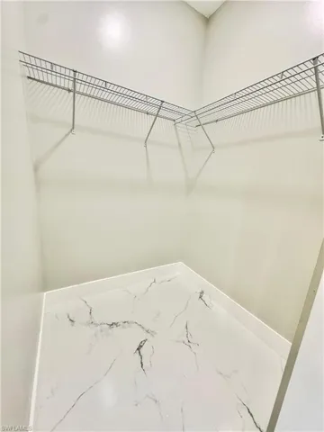 Walk in closet with marble finish floors