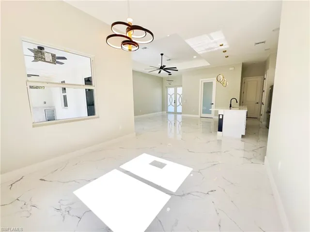 Unfurnished room with light marble finish flooring and french doors