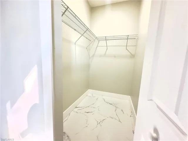 Spacious closet with marble look tile flooring