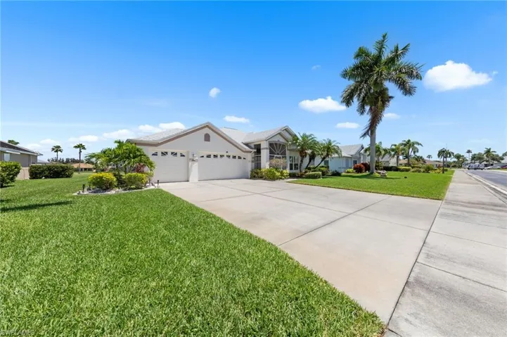 Single story home with concrete driveway, an attached garage, a front yard, and a residential view
