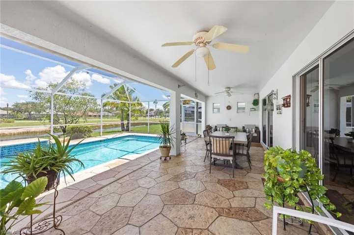 Outdoor pool featuring a ceiling fan, a patio, outdoor dining space, and a lanai