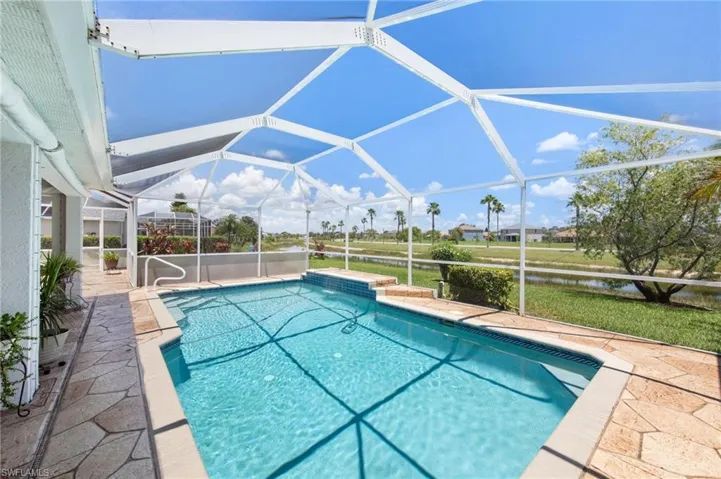 Swimming pool featuring a patio area, a water view, and glass enclosure