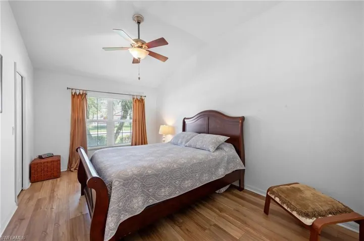 Bedroom featuring vaulted ceiling, light wood finished floors, and a ceiling fan
