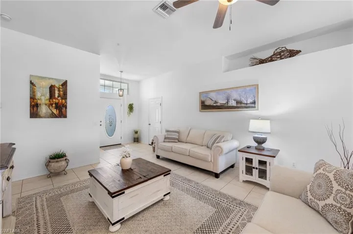 Tiled living room featuring ceiling fan