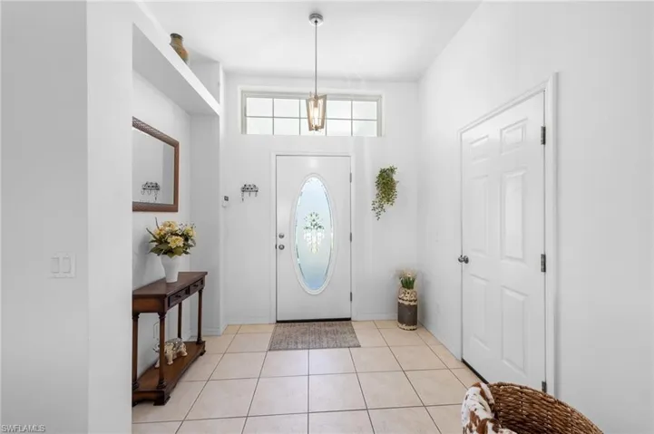 Entryway with light tile patterned floors and baseboards