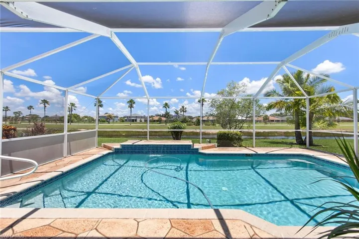 Swimming pool featuring a water view, a lanai, and a patio area