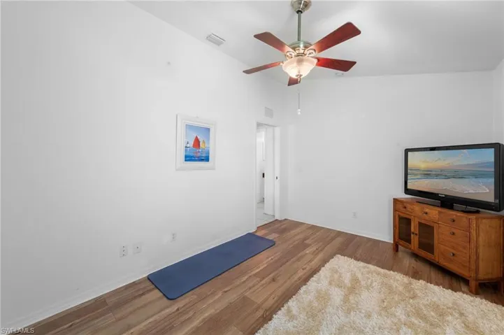 Unfurnished living room with wood finished floors and a ceiling fan