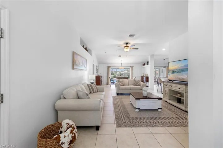 Living area with light tile patterned flooring, ceiling fan, and recessed lighting
