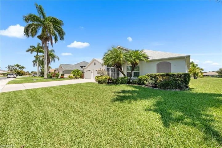 Ranch-style home featuring driveway, stucco siding, a front yard, and a garage