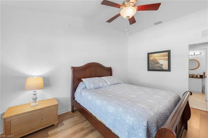 Bedroom featuring light wood-type flooring, lofted ceiling, and ceiling fan