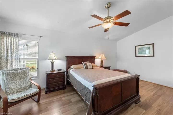 Bedroom featuring vaulted ceiling, light wood-style floors, and ceiling fan
