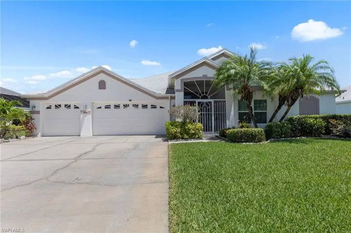 Ranch-style home with an attached garage, stucco siding, a front lawn, and driveway