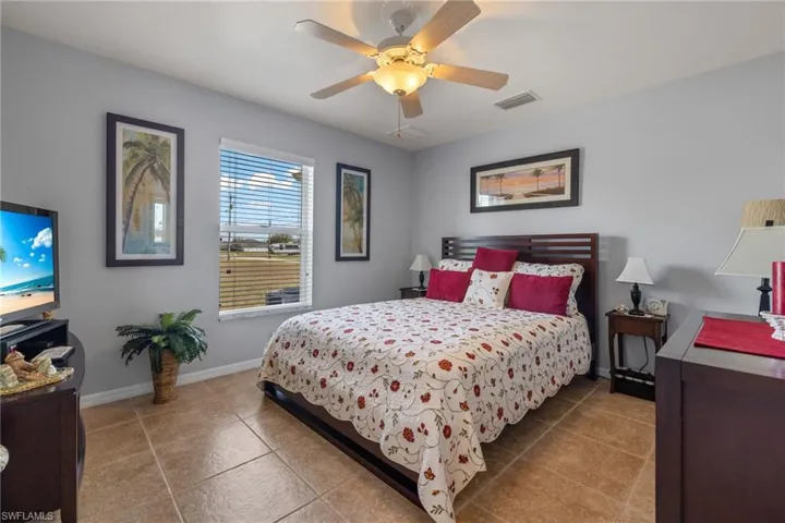 Tiled bedroom featuring ceiling fan