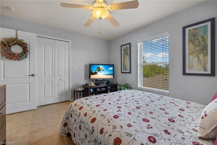 Tiled bedroom with a closet and ceiling fan